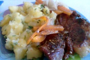 Friptura de porc pe pat de ceapa si morcovi cu cartofi natur