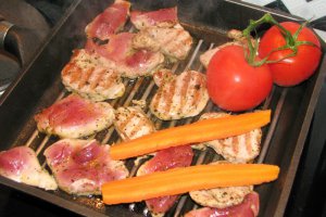 Porc la grătar pe pat de legume verzi, cu morcovi și roșii
