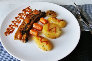 Piept de porc cu os pe pat de legume servit cu sos chili
