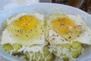 Aperitiv ochiuri pe pat de cartofi si branzeturi, la cuptor