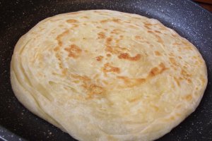 Paratha sau paine plata foietajata preparata la tigaie