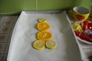 Pastrav la cuptor, pe pat de portocala, lamaie si limeta