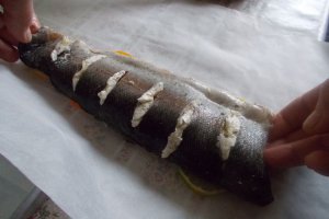 Pastrav la cuptor, pe pat de portocala, lamaie si limeta