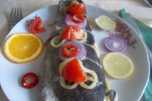 Pastrav la cuptor, pe pat de portocala, lamaie si limeta